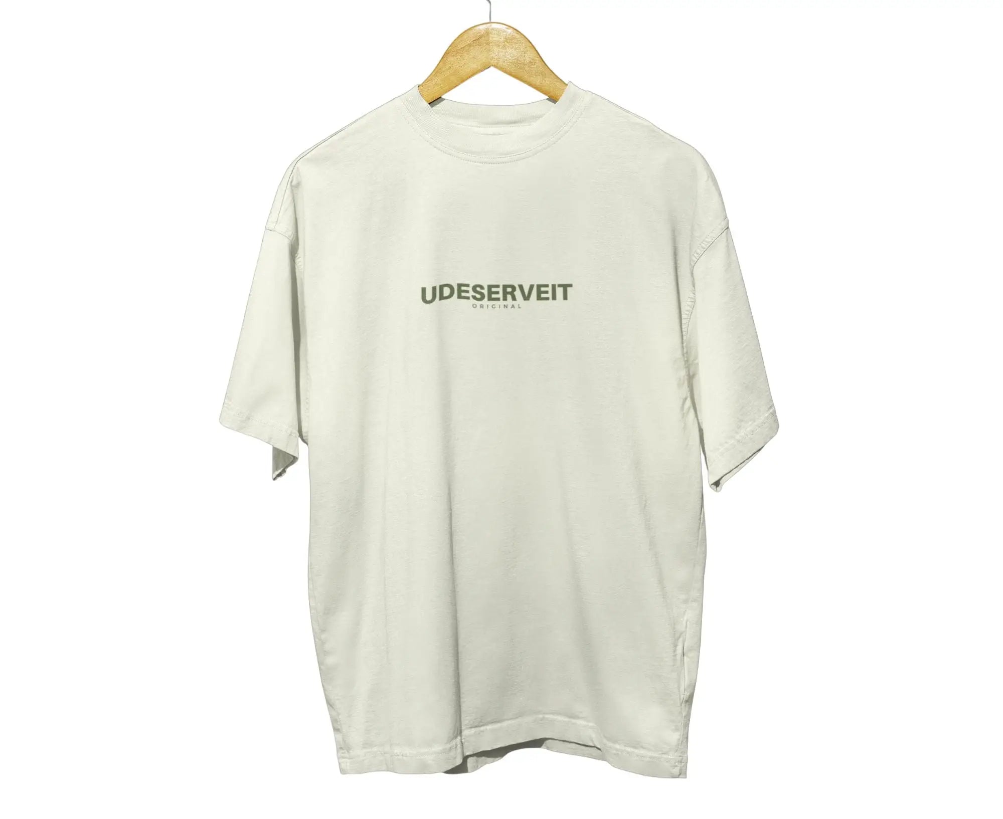 Beige t-shirt with 'UDESERVEIT' logo on a wooden hanger against a white background