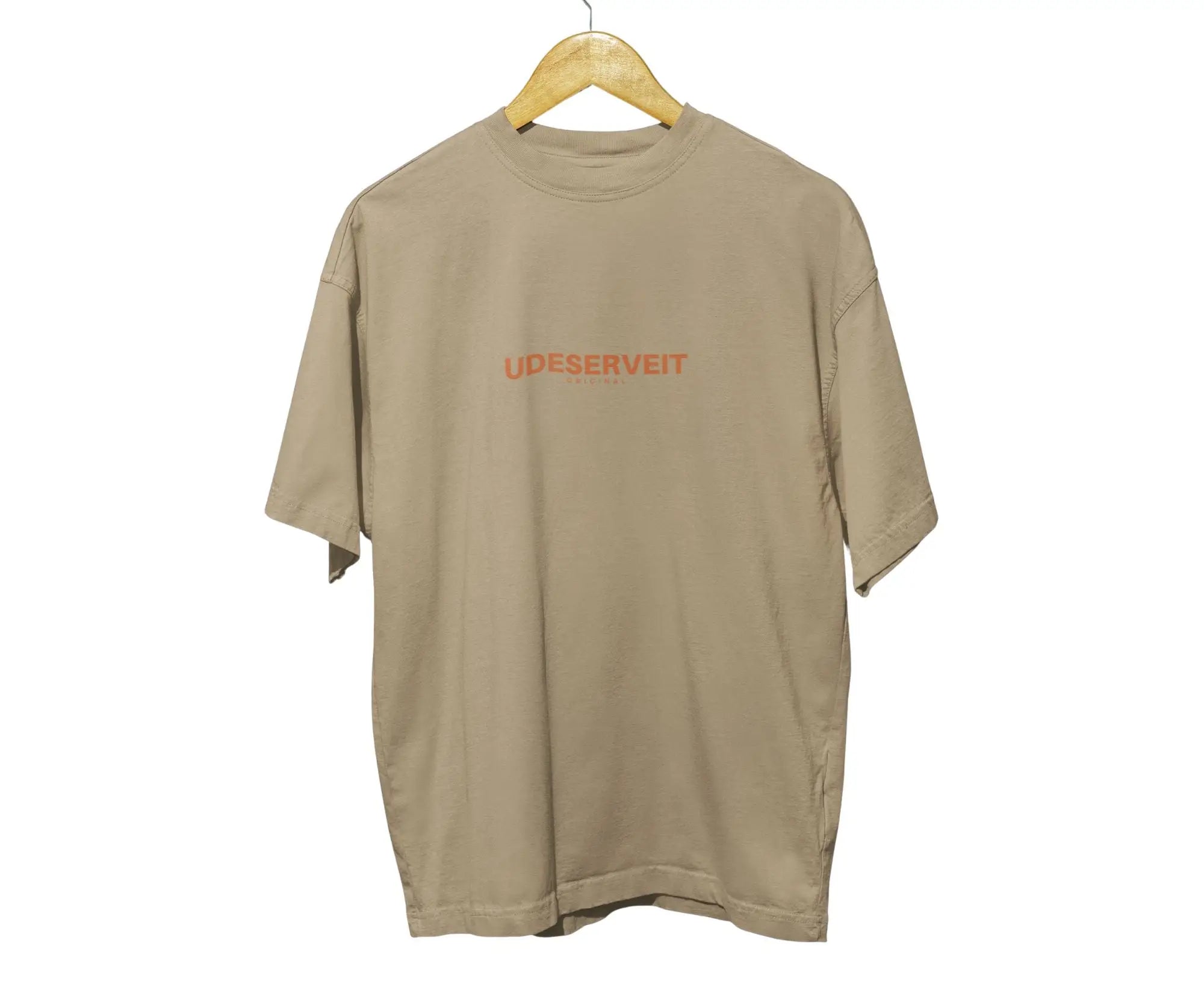Beige t-shirt with 'UDESERVEIT' text on a hanger against a white background